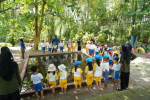 Para siswa tengah mencoba keseruan terapi ikan untuk kaki di kolam Sobo Ndeso (Foto/Humas GIS 3 Jogja)