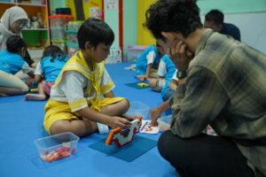 Didampingi gurunya, siswa mencoba menyusun robot sederhana