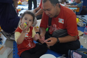 Potret seorang anak menunjukkan karya "Makanan Kesukaanku" buatannya bersama sang ayah