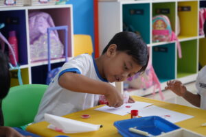 Siswa tampak serius menyemprotkan cairan ke gambar buatannya