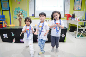 Potret tiga orang siswa mengenakan medali yang diberikan sebagai apresiasi atas pekerjaan mereka