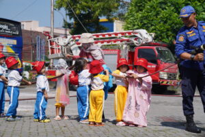 Siswa diberi kesempatan untuk mencoba memadamkan api dengan selang damkar