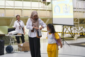 Seorang siswa putri terlihat berinteraksi dengan pekerja Balai Teknik Sabo