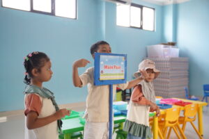 Siswa Kindy-2A tampak sedang mempromosikan area bermain pasir yang mereka sediakan