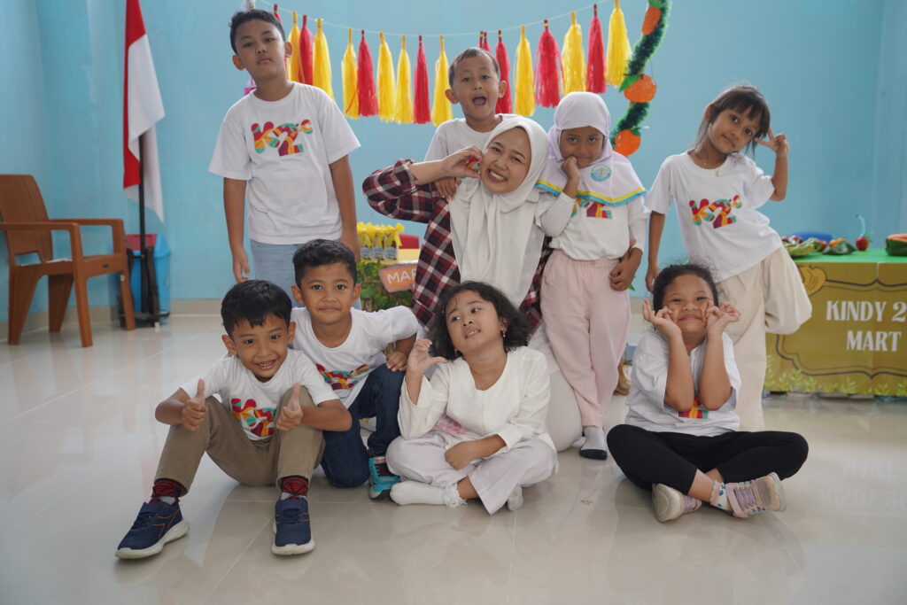 Kelas Kindy-2C berpose bersama gurunya di depan booth miliknya