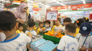Ditemani Ms. Fefin, siswa-siswi memilih-milih jeruk dan susu untuk dibeli