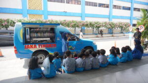 Siswa tampak duduk rapi di depan lobi PG-K. Di hadapan mereka, ada mobil perpustakaan keliling Jaka Tingkir