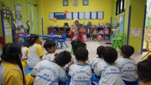 Para siswa sedang memperhatikan Ms. Ulfi yang menjelaskan tentang Art and Craft Area
