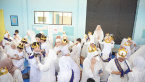Suasana haru dan bahagia tercipta saat siswa memasangkan mahkota dan selempang kepada parent-nya
