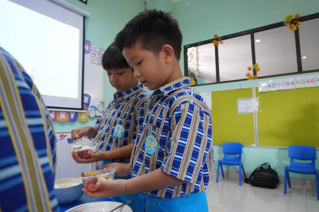 Dua orang siswa tampak sedang meracik saladnya