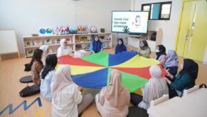 Dalam barisan melingkar, parents diajak memainkan rainbow parachute