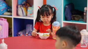 Potret seorang anak sedang menyantap nasi kuning