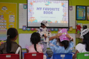 Seorang anak menceritakan buku favoritnya kepada teman-temannya