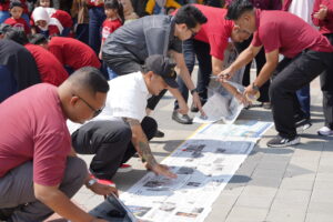 Potret para ayah sedang merangkai "roda" dari koran untuk Hamster Wheel Challenge