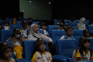 Bersama gurunya, anak-anak tampak serius menonton film tentang dunia penerbangan Indonesia