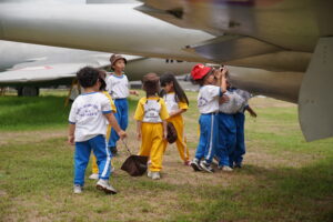 Anak-anak melihat sayap pesawat dari dekat seolah sedang penasaran