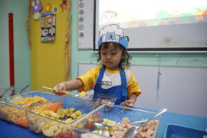Seorang siswa Playgroup tampak sedang memilih komponen saladnya